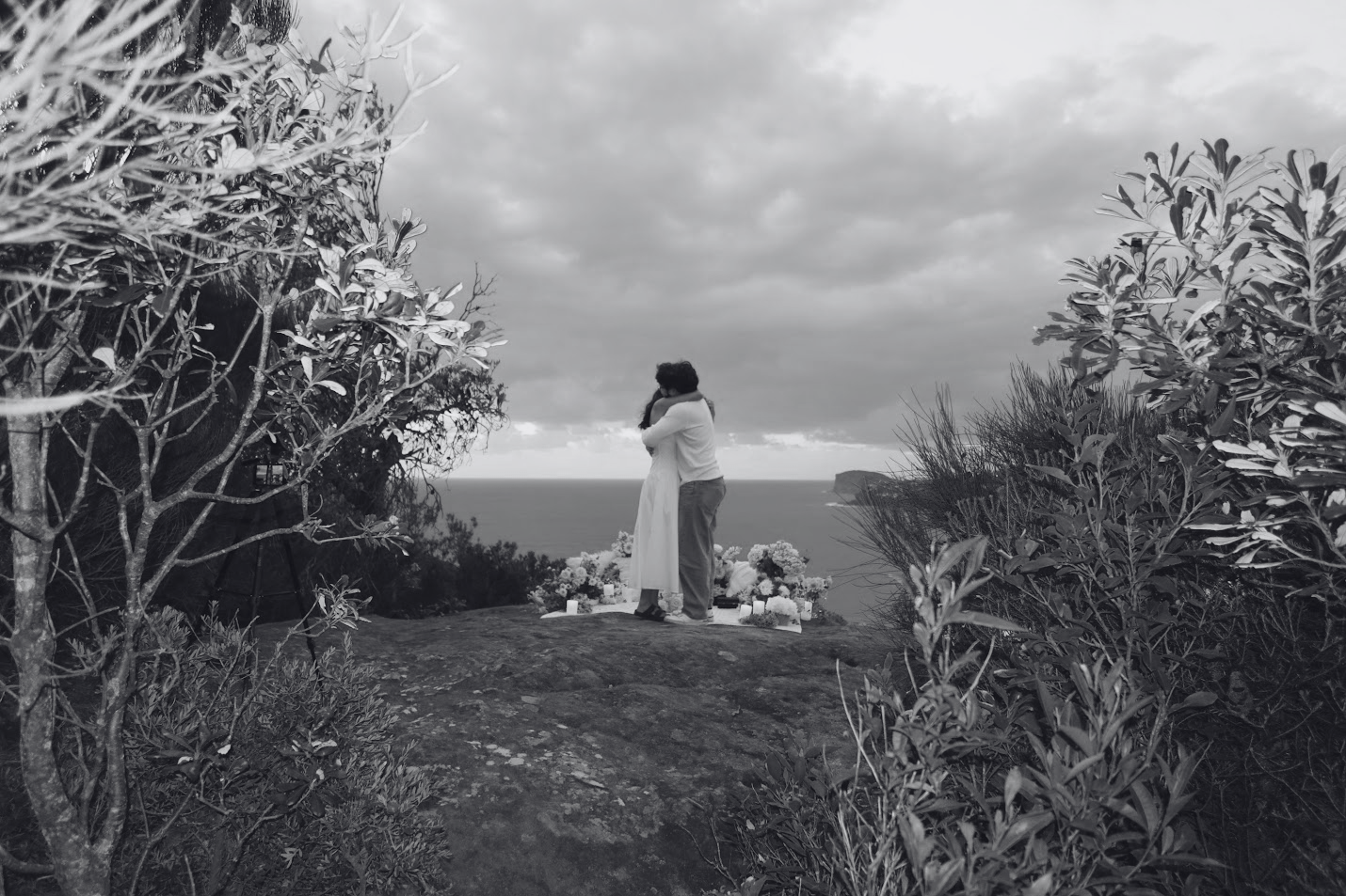 Belinda and Thomas embracing beside the ocean
